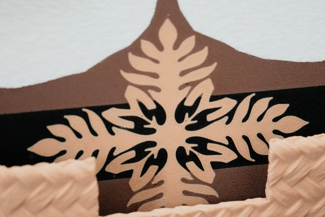 Close-up of the Munching Mahu logo on a coaster framed by lauhala-inspired texture