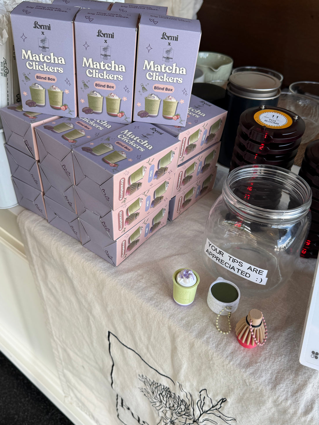 Pua Blooms matcha clicker blind boxes and sample clickers displayed at a pop-up